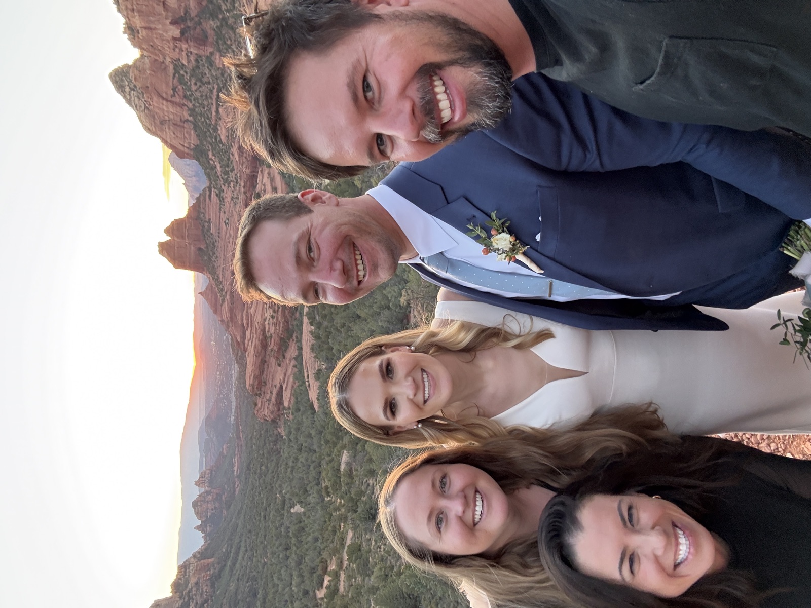 Wedding professionals with a newlywed couple overlooking Sedona's red rocks