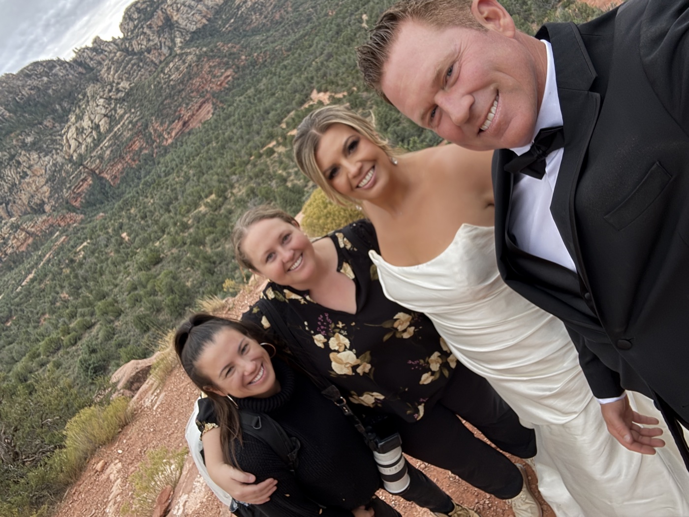 A Sedona wedding couple with members of their photo and film team on the red rocks